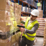 male-warehouse-worker-using-bar-code-scanner-analyze-newly-arrived-goods-further-placement-storage-department