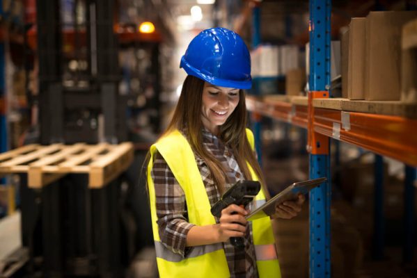 smiling-female-worker-holding-tablet-bar-code-scanner-checking-inventory-distribution-warehouse